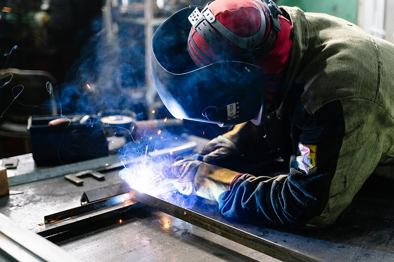 Welder working a job in his workshop with welding gear