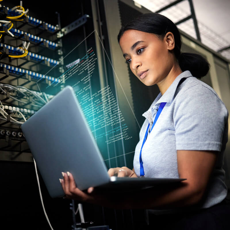 Young, female Computer Information Science CIS major or analyst holding laptop near server rack