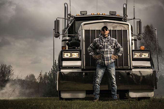 career professional driver standing beside his trailer truck